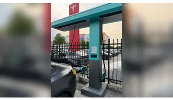 比亞迪閃充充電樁全景，展示頂部閃充標誌、懸吊充電線及 v.NEXT-mini 轉接頭與車輛的接駁位置