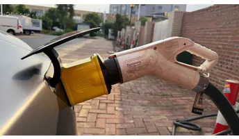 萬城萬充白色國標充電槍經黃色 v.NEXT-mini 轉接頭接駁車輛充電口的近照